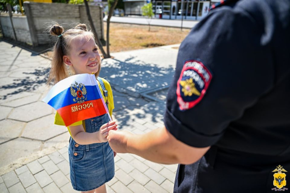 В Херсонской области полицейские раздали геничанам флажки-триколоры в честь Дня государственного флага России В Херсонской области полицейские раздали геничанам флажки-триколоры в честь Дня государственного флага России