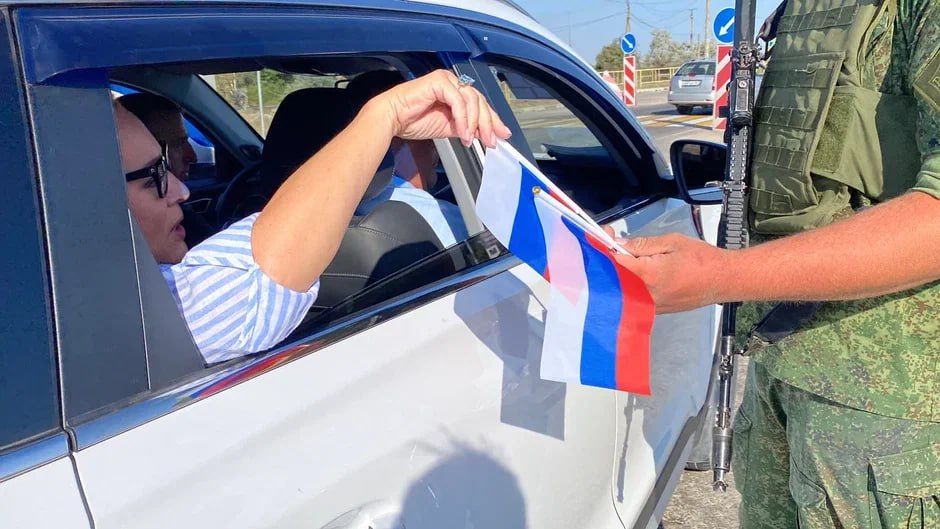 В честь Дня Государственного флага волонтеры «Молодой Гвардии Единой России» вместе с военнослужащими вручают жителям Херсонской области ленты-триколоры и флажки В честь Дня Государственного флага волонтеры «Молодой Гвардии Единой России» вместе с военнослужащими вручают жителям Херсонской области ленты-триколоры и флажки